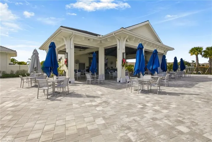 View of home's community with outdoor dining space and a patio