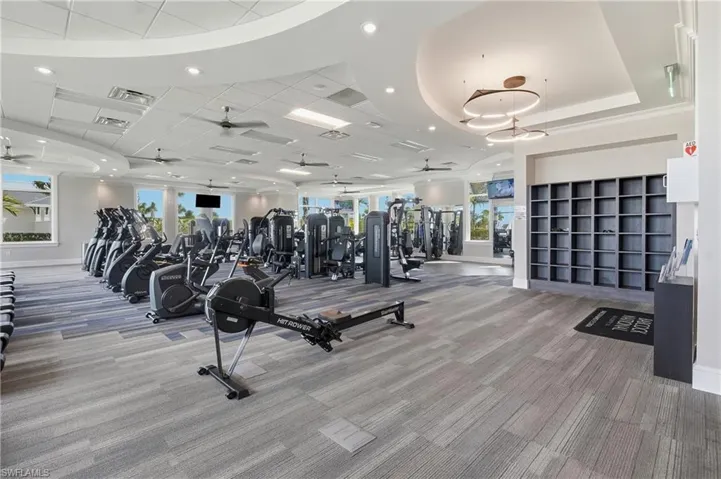 Exercise room with recessed lighting and a raised ceiling