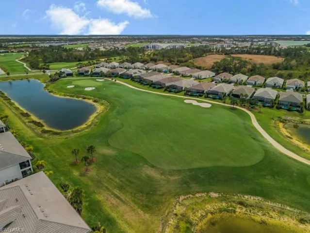 Aerial perspective of suburban area featuring a local golf course and a nearby body of water