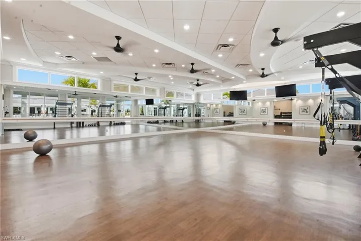 Misc room with ceiling fan, healthy amount of natural light, recessed lighting, and a high ceiling