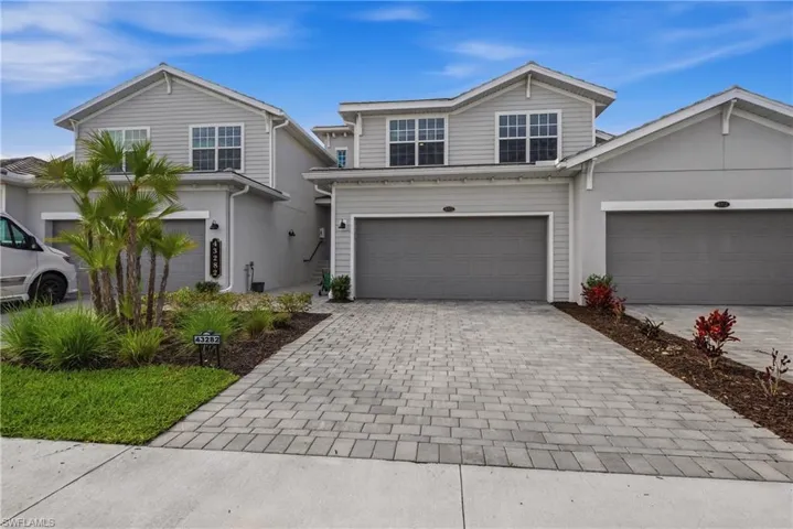 Traditional-style home with decorative driveway and an attached garage