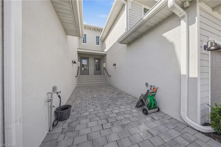 Doorway to property featuring stucco siding and a patio