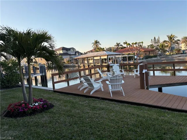 Dock featuring a water view, a yard, and a residential view