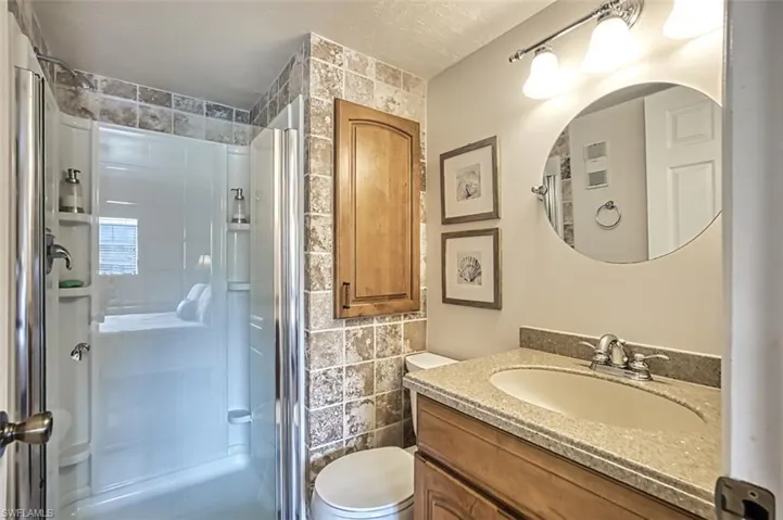 Bathroom featuring tile walls, toilet, and vanity