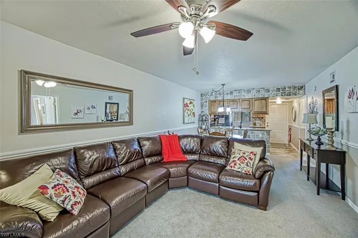 Carpeted living room with ceiling fan