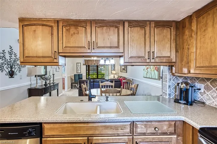Kitchen featuring stove, sink, dishwasher, and decorative backsplash