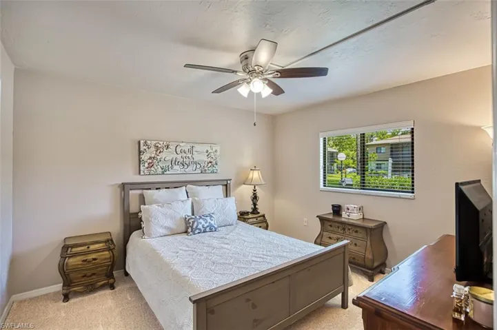 Bedroom with light colored carpet and ceiling fan