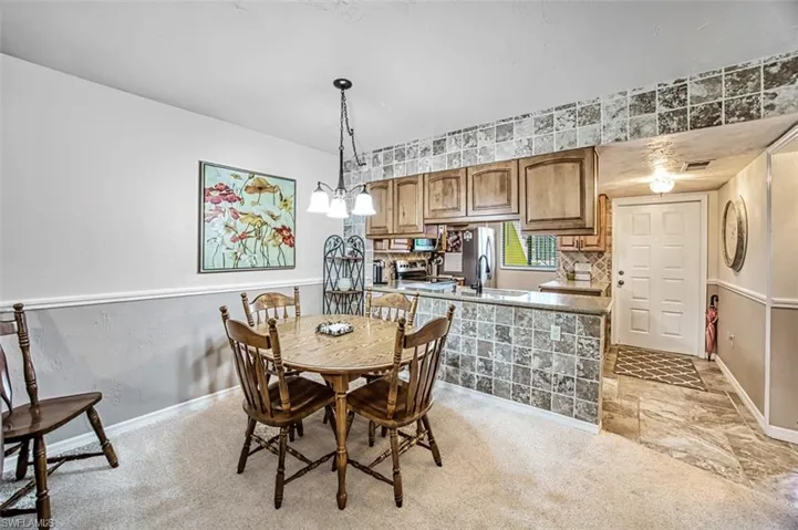 Dining room featuring a notable chandelier, light carpet, and sink