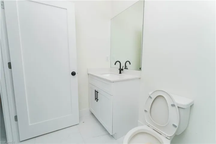 Half bath with marble look tiles and vanity