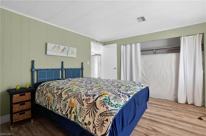 Bedroom featuring wood finished floors, a closet, and wooden walls