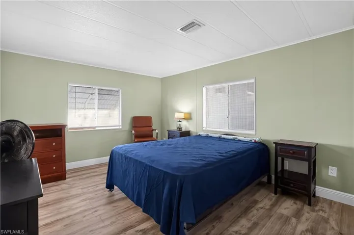 Bedroom featuring ornamental molding and wood finished floors