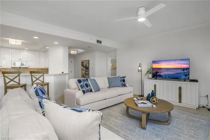 Living room with ceiling fan and ornamental molding