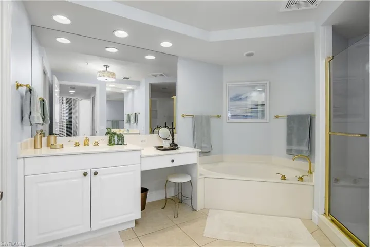 Bathroom featuring tile patterned floors, independent shower and bath, and vanity