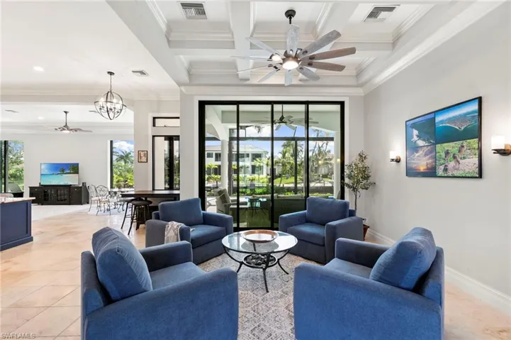 Living room with ceiling fan, crown molding, light tile patterned floors, beamed ceiling, and coffered ceiling