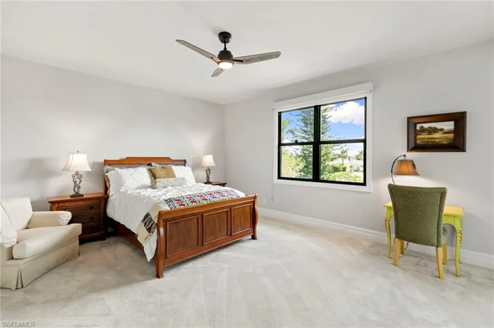Bedroom with light colored carpet and a ceiling fan