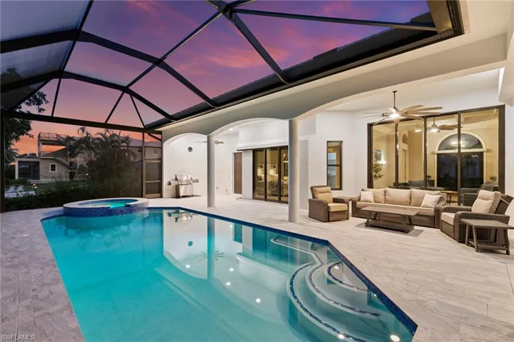 View of swimming pool featuring a pool with connected hot tub, outdoor lounge area, a sunroom, a patio area, and a lanai