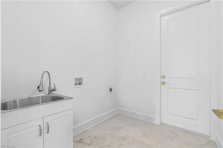 Laundry room with washer hookup, light marble finish floors, and electric dryer hookup