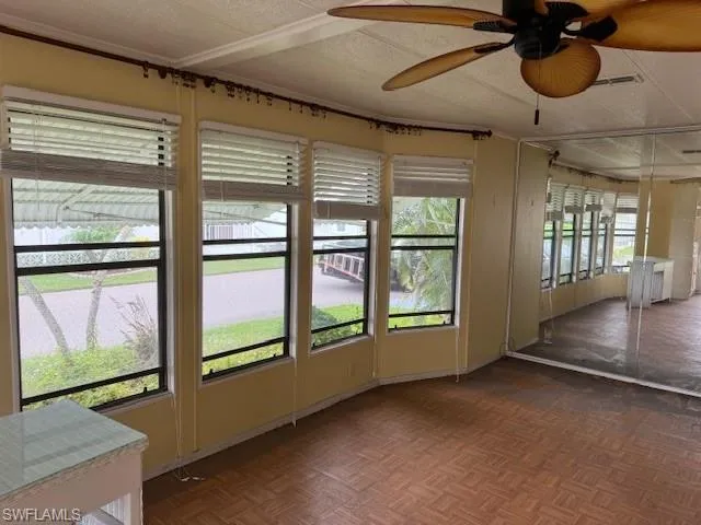 Unfurnished sunroom featuring ceiling fan