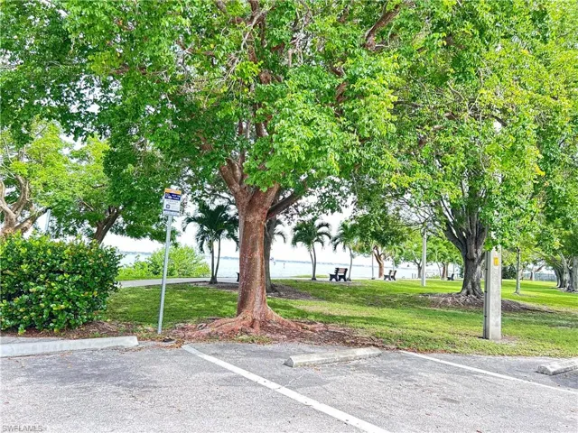 View of car parking with a lawn and river