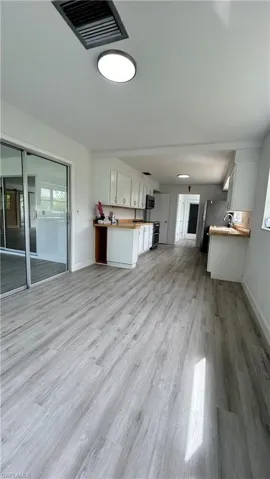 Another dining area or office space room featuring sink and light hardwood / wood-style flooring