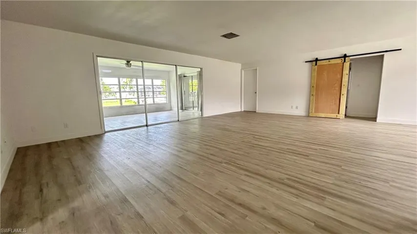 Dining room area with ligth and durable hardwood / wood-style flooring and a barn door