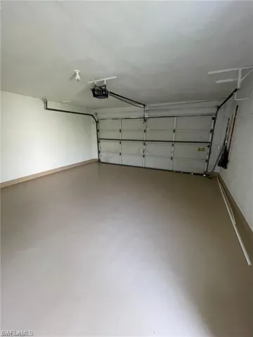Clean Garage with Shelving and Cabinet areas for storage