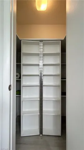 Spacious custom made pantry closet featuring wood-type flooring