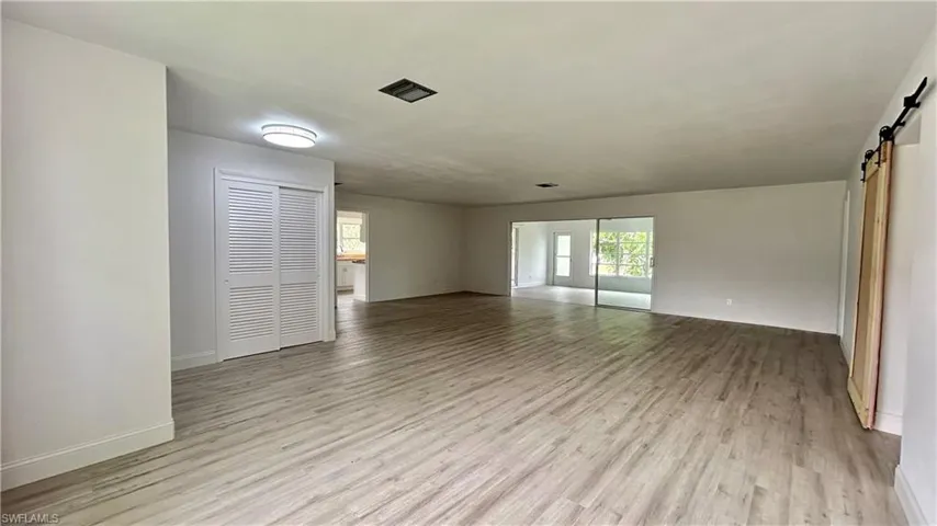 Living room area with light hardwood / wood-style flooring and a barn door
