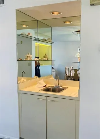Wet bar with recessed lighting and a sink