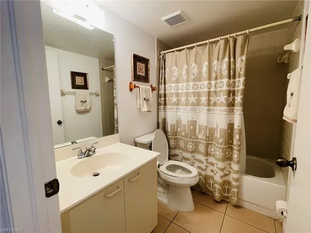 Guest bathroom featuring tile patterned flooring, vanity, and shower / bathtub combination
