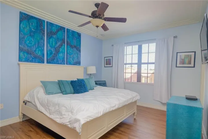 Bedroom with hardwood / wood-style flooring, ceiling fan, and crown molding