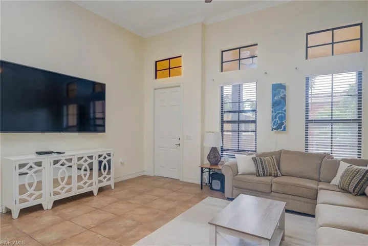 Living room with tile patterned floors and crown molding