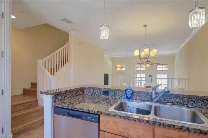 Kitchen featuring ornamental molding, ceiling fan with notable chandelier, sink, pendant lighting, and dishwasher