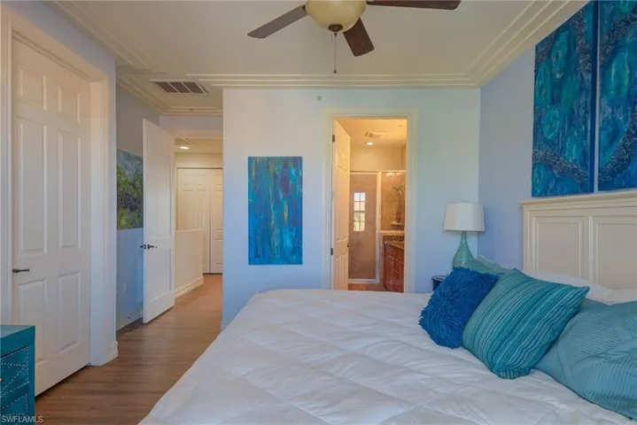 Bedroom featuring ensuite bath, ceiling fan, hardwood / wood-style floors, and crown molding