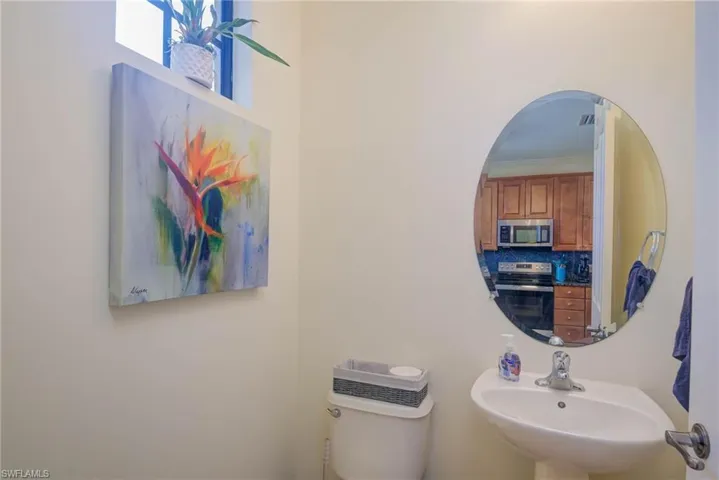 Bathroom featuring tasteful backsplash, crown molding, sink, and toilet