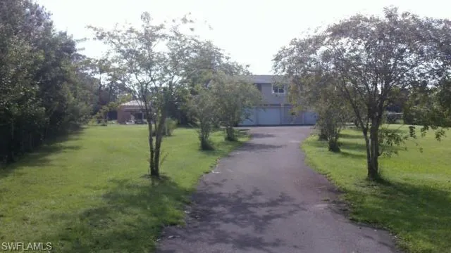 View of front of house with a front yard, an attached garage, and aphalt driveway