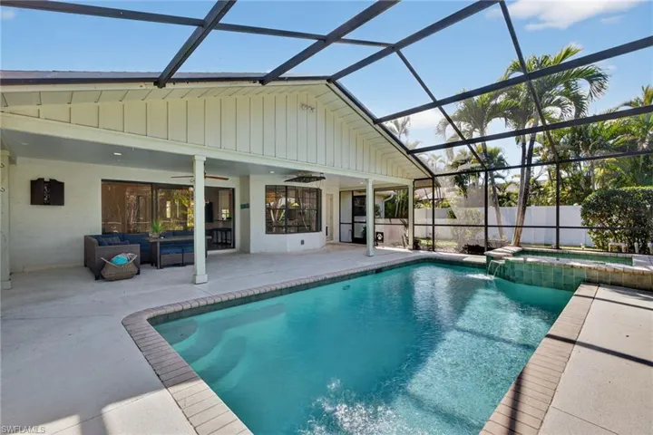 Integrated pool / spa with a sunroom, glass enclosure, a patio area, and an outdoor living space