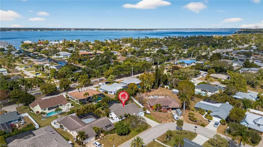 Aerial view of property and surrounding area with nearby suburban area and a nearby body of water