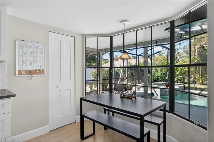 Dining area with light wood-style flooring and expansive windows