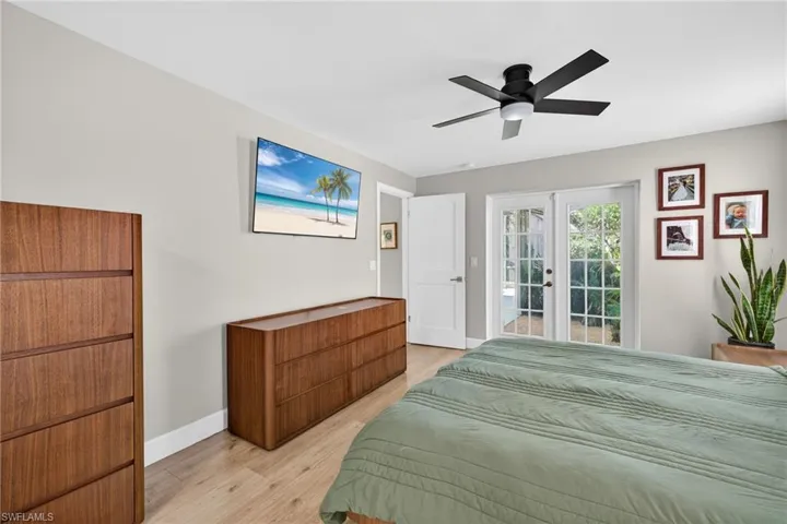 Bedroom featuring french doors, light wood finished floors, access to outside, and a ceiling fan