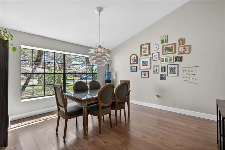 Dining space with light wood finished floors and lofted ceiling