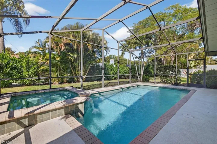 Relaxing pool / spa with a lanai, a sunroom, and a patio