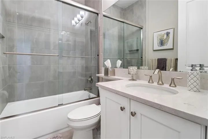 Full bathroom featuring vanity, toilet, and enclosed tub / shower combo