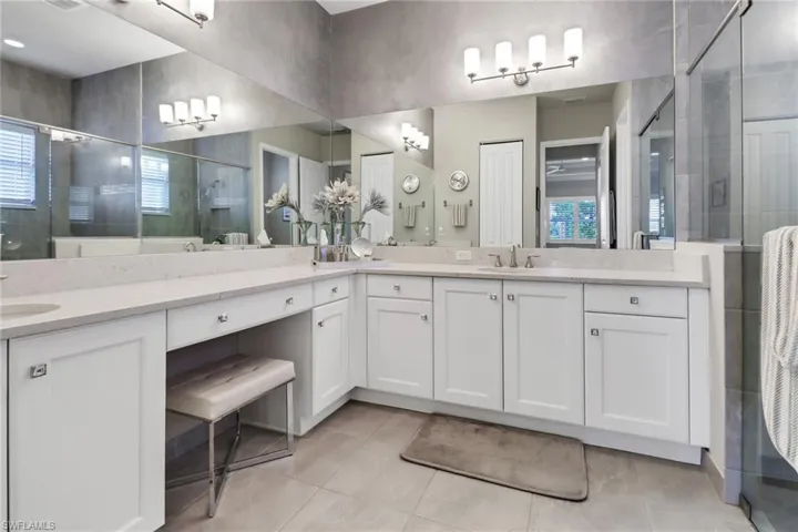 Bathroom with tile patterned flooring, vanity, and a shower with shower door