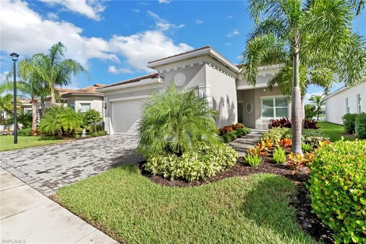 Mediterranean / spanish-style house with a garage and a front lawn