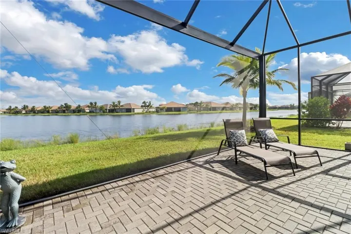View of patio with a lanai and a water view