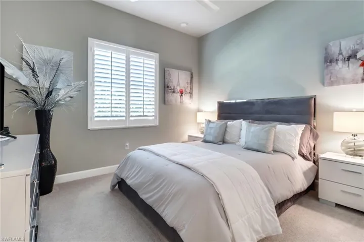 Carpeted bedroom featuring ceiling fan