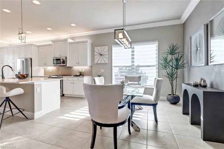 Dining space featuring light tile patterned floors, sink, and ornamental molding