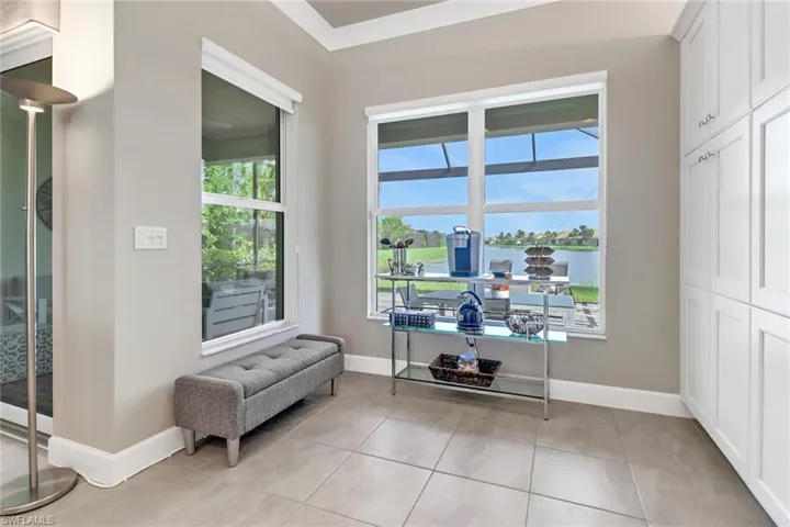 Sitting room with plenty of natural light, a water view, and light tile patterned flooring
