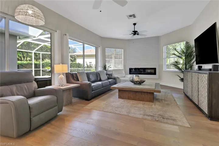 Family room with light wood-style floors, a fireplace, ceiling fans